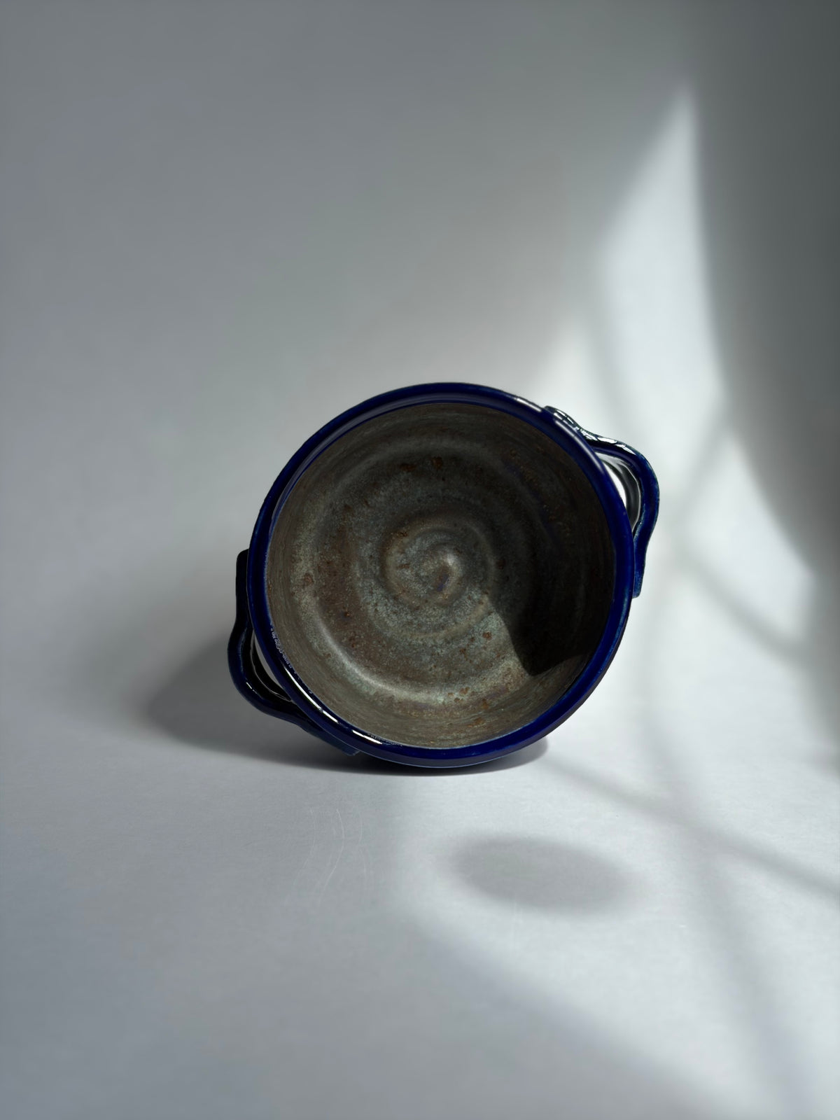 a miniature stoneware casserole with greenish brown interior and blue exterior