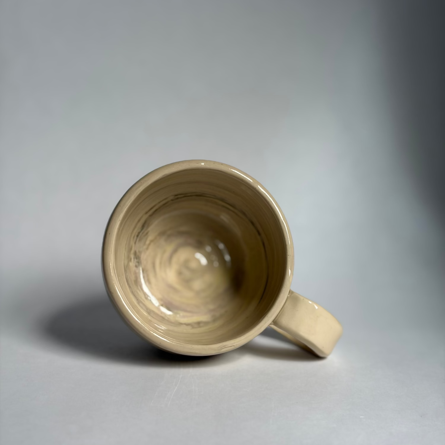 Photo of a beige mug with marbled colors against a white background.