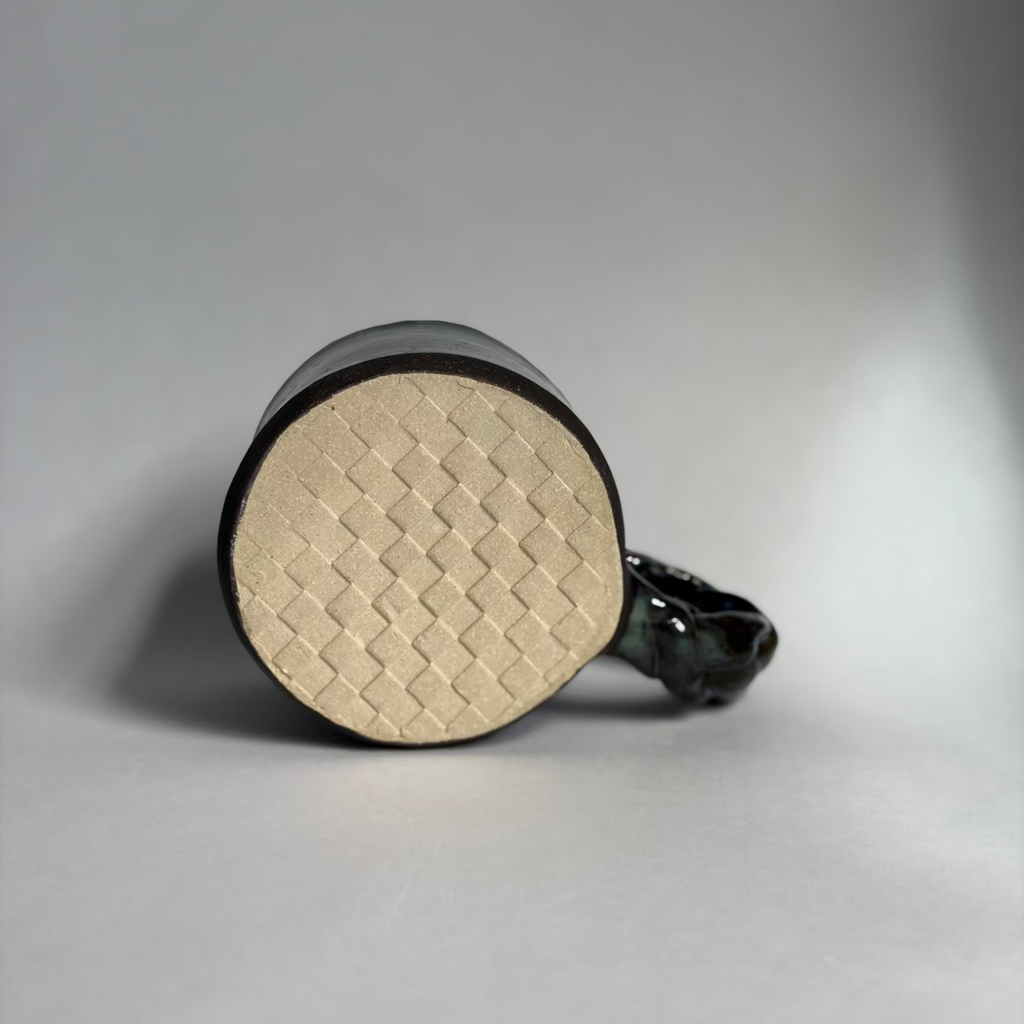Base view of a mug with a braided handle revealing an embossed checkered pattern.